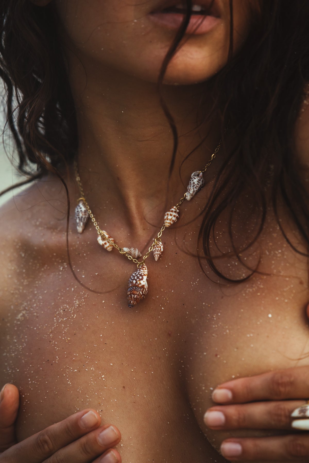 Woman wearing a bohemian gold shell necklace, featuring natural seashells and beach-inspired design. Perfect for ocean-inspired fashion, coastal elegance, and nature-inspired jewelry lovers.